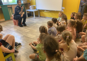 Dzieci w skupieniu słuchają pogadanki na temat bezpieczeństwa w ruchu drogowym