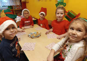 Grupka dzieci smakuje pierniki i pozuje do wspólnego zdjęcia