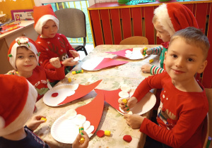 Grupka chłopców wykonuje mikołaje z talerzyków papierowchh