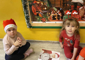 Otylia i Emilka układają puzzlowe obrazki z Mikołajem