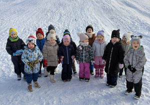 Dzieci z grupy I na tle górki w zimowej szacie