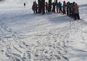 dzieci gęsiego idą po śniegi