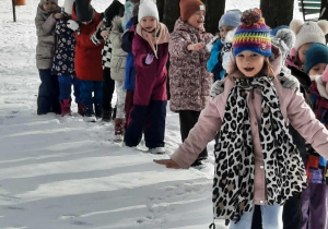 dzieci idą gęsiego po śniegu