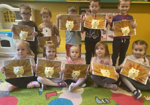 Dzieci z grupy I trzymają swoje prace plastyczne: jeże z liści