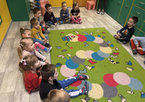 Dzieci z grupy I słuchają bajki czytanej przez Panią Kasię z fundacji Zaczytani w ramach Bajkoterapii