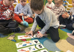 Mykola i Michał przeliczają dinozaury i dopasowują odpowiednie cyfry