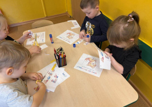 Czego koty potrzebują do szczęścia - dzieci wycinają i przyklejają odpowiednie obrazki