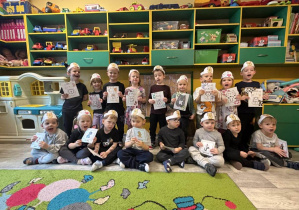 Dzieci z grupy I w opaskach z kotami trzymają w ręku napis: Dzień kota