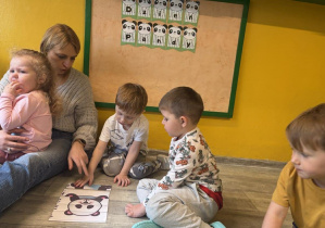 Dzieci układają obrazki z pandami pocięte na kawałki