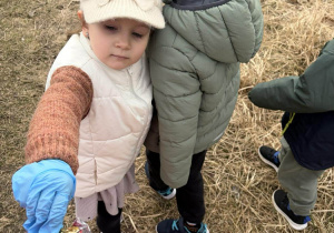 Alisa i inne dzieci sprzątają śmieci na pobliskiej polanie.