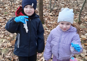 Chłopiec i dziewczynka trzymają w rękach śmieci