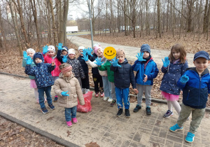 Grupa dzieci pozuje do zdjęcia machając