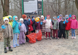 Grupa dzieci pozuję do zdjęcia w rękawicach ochronnych podczas stania na chodniku