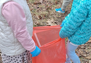 Dwie dziewczynki trzymają worek ze śmieciami