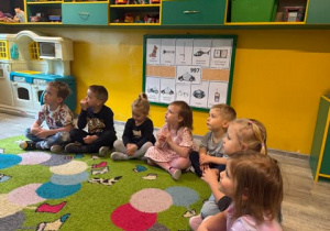 Dzieci w kole z zaciekawieniem słuchają opowiadania